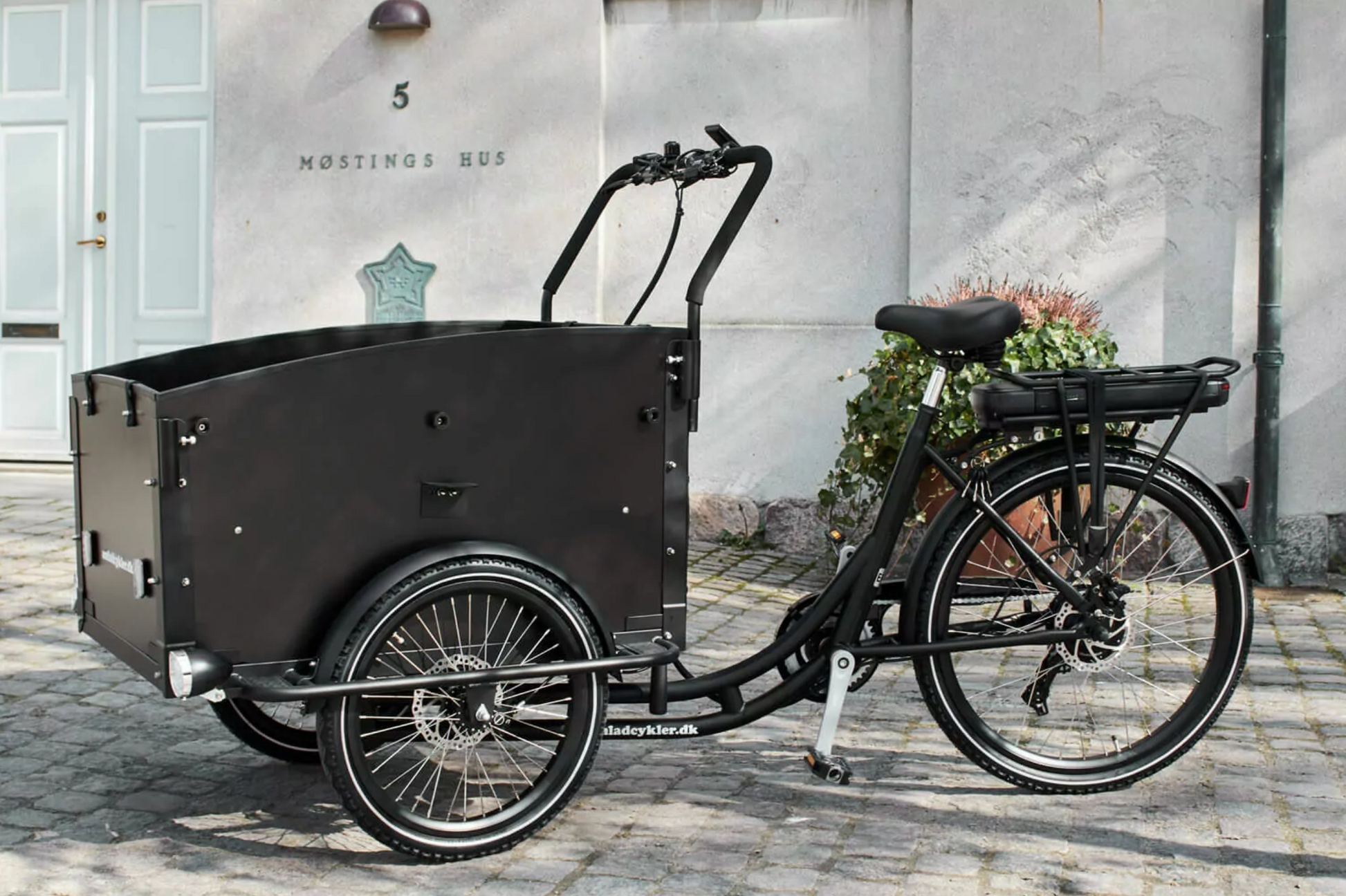 Side shot of the Amcargobike Ultimate Curve in black, in an urban setting. 