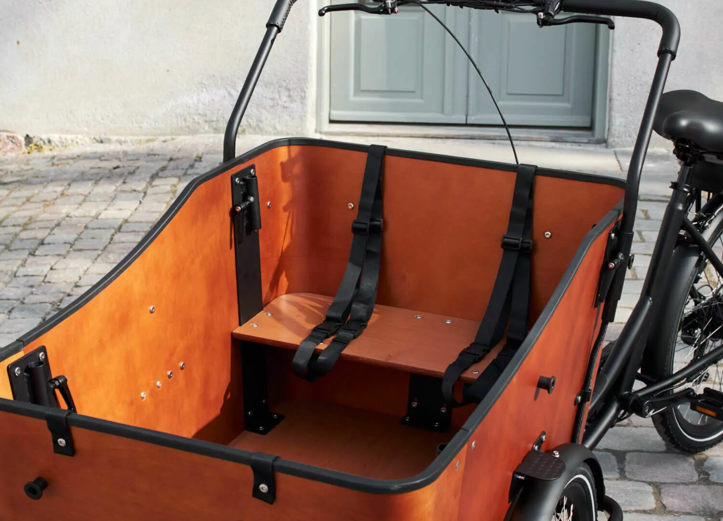 Close up shot of the Amcargobike Ultimate Harmony cargo bike, detailing the wooden box, showing the children's bench and seat belts.