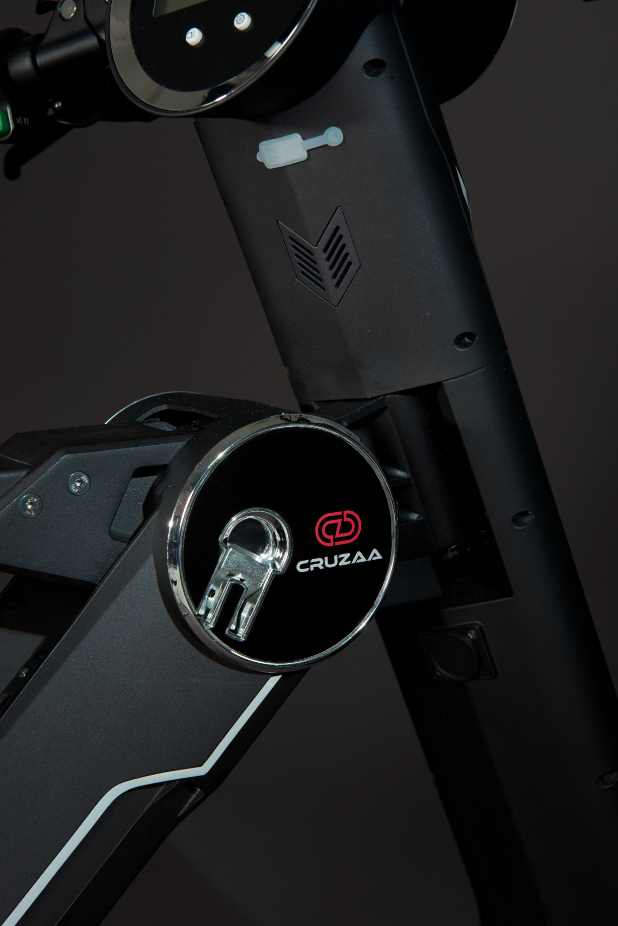 The Cruzaa E-Scooter Pro in Carbon Black standing in a studio setting showing details of the logo. 