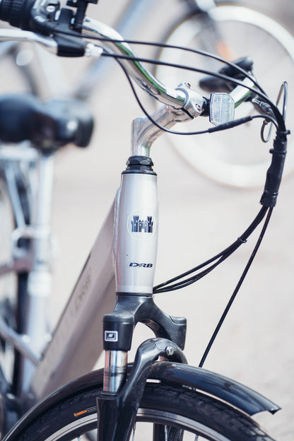 Lifestyle shot of the Dallingridge Harlow model in Silver, detail of the head tube and logo. 