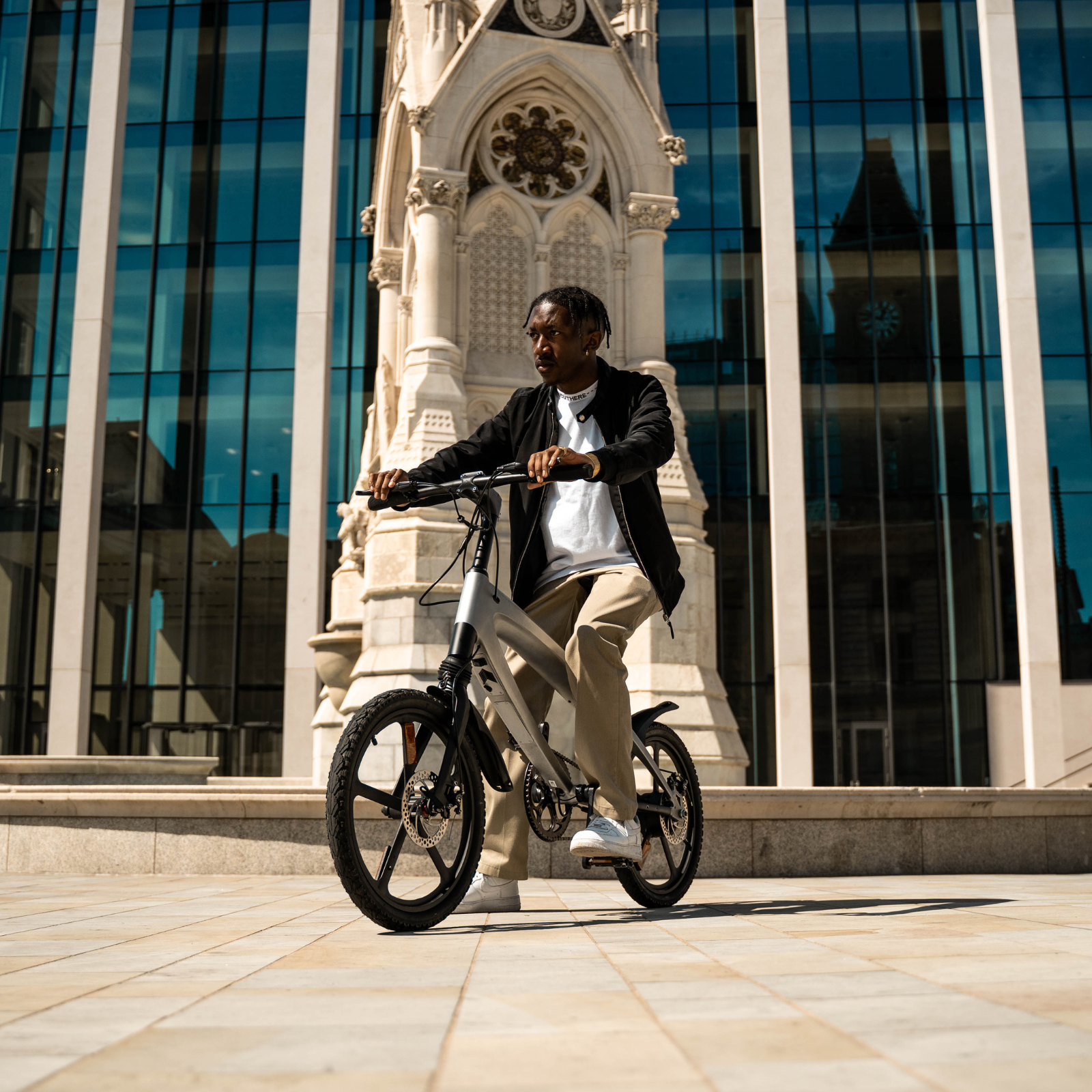 The Cruzaa E-Bike in Gunmetal Grey, in an urban setting with rider.